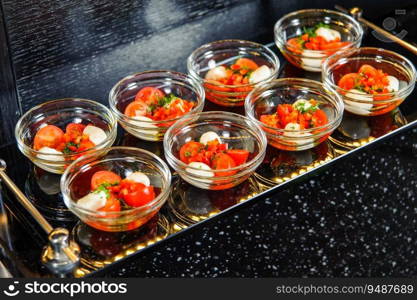 A closeup shot of a set of tomato salads in small bowls on a tray. Closeup shot of a set of tomato salads in small bowls on a tray