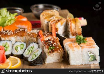 A closeup shot of a sushi set on a wooden plate. Closeup shot of a sushi set on a wooden plate