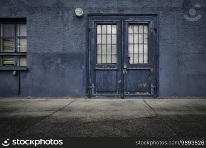 A closeup shot of an old wooden door of a blue building during daytime. Closeup shot of an old wooden door of a blue building during daytime