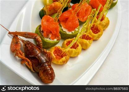A closeup shot of cooked cancer with appetizers on skewers on the plate. Closeup shot of cooked cancer with appetizers on skewers on the plate