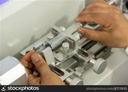 A closeup shot of hands working on a machine in a medical production warehouse for syringes. Closeup shot of hands working on a machine in a medical production warehouse for syringes