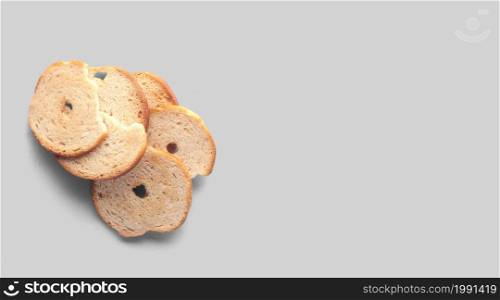 A closeup view of dry bread slices under the lights isolated on a grey background.