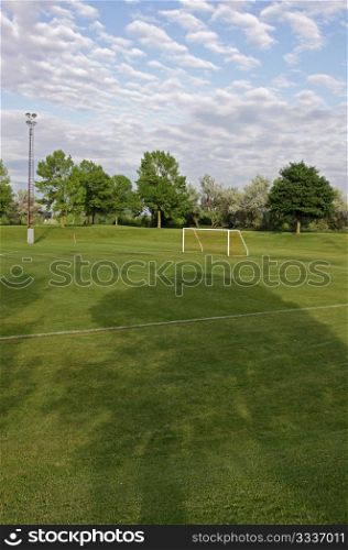 A cloudy unoccupied soccer field with trees in the background. (HDR photograph). Soccer Pitch