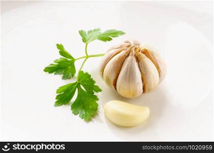 A clove of garlic and some leaves of parsley