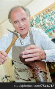 a cobbler is repairing a sole