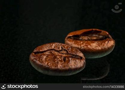 a coffee beans macro shot with water drops and reflection. Black background