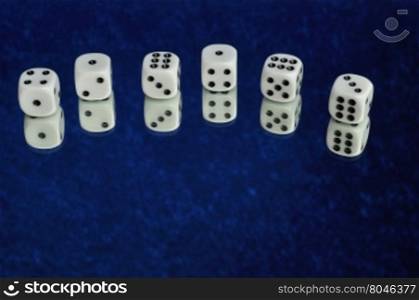 A collection of dice that is reflection onto a blue background