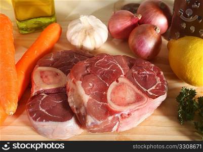 A collection of ingredients for Ossobuco (italian veal shank stew) on a chopping board.