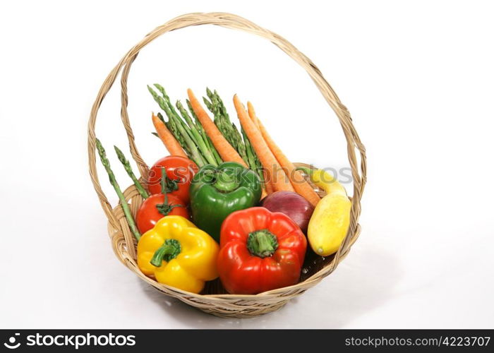 A colorful basket of harvest fresh vegetables. White background.