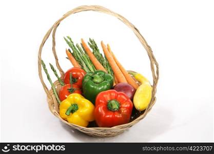 A colorful basket of harvest fresh vegetables. White background.