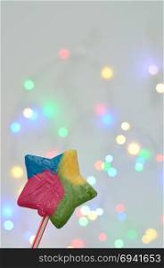 A colorful star shape candy with a out of focus light background