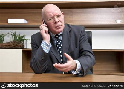 A company director appearing to be in tense negotiations during a mobile telephone conversation