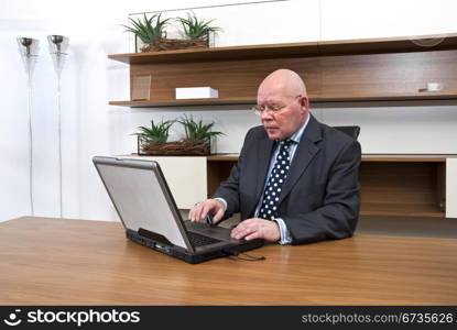 A company director typing on his laptop