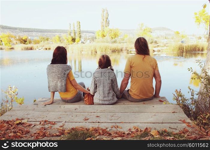 A complete family sitting by the lake