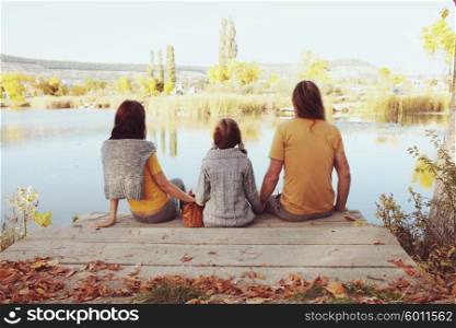 A complete family sitting by the lake