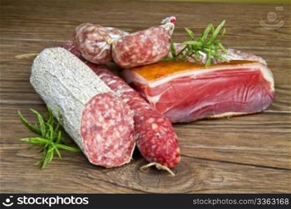 A composition of different sorts of cold cuts on wooden table