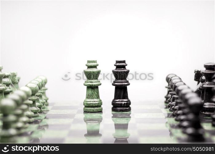 A composition of two kings between the raws of chess pieces.