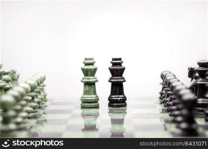A composition of two kings between the raws of chess pieces.