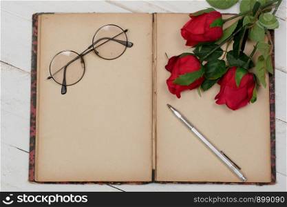 a concept romantic, old notebook, roses and glasses