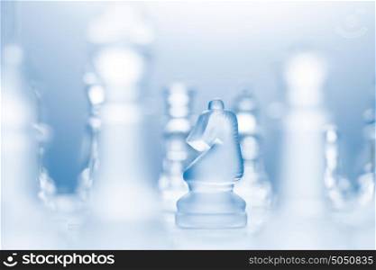 A conceptual photo of a transparent knight on a chessboard making an l-shaped move.
