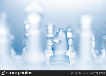 A conceptual photo of a transparent knight on a chessboard making an l-shaped move.