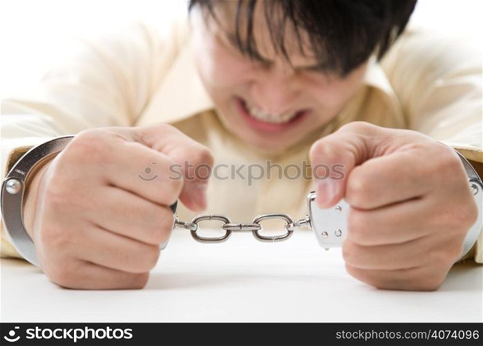 A conceptual shot of a stressed businessman being handcuffed