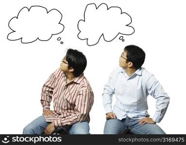 A conceptual shot of two businessmen looking at their own thoughts