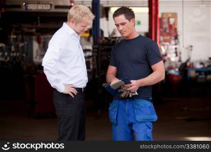 A confident mechanic showing work report to business man