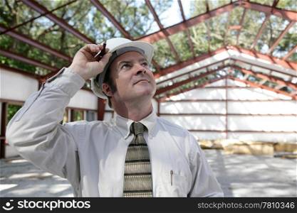 A construction engineer surveying his steel frame building with pride.