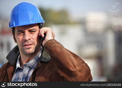 A construction foreman talking on his mobile phone