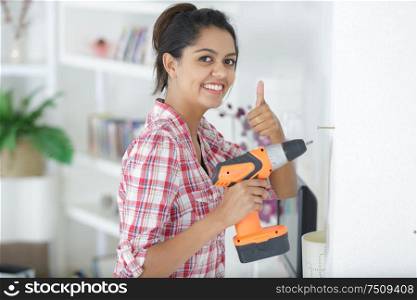 a construction woman is drilling