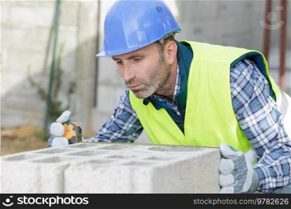 a construction worker bricklaying the wall indoors