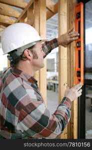 A construction worker checking that a newly installed window is level. Vertical view. Authentic and accurate content.