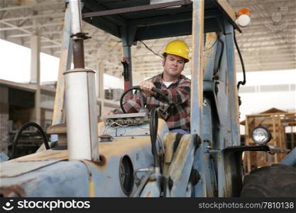 A construction worker driving an earth mover on a construction site.
