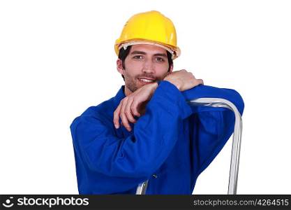 A construction worker resting on a ladder.