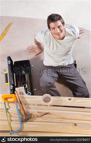 A construction worker with tools and wood