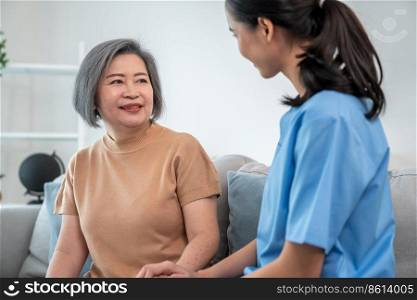 A contented senior woman visited by her personal caregiver and hold each other&rsquo;s hands.. A contented senior woman visited by her personal caregiver.