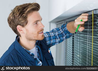 a contractor measuring venetian blinds