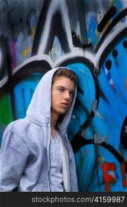 a cool-looking young man in front of graffiti