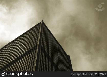 A corporate building with stormy clouds in the background