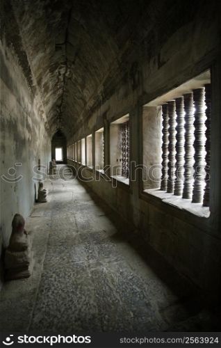A corridor of the Angkor temples in Siem Reap, Cambodia. The heads of the Buddha statues have been stolen or vandalized over the years of the temples neglect.