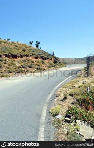 A country road in Crete with trees and of the greenery.