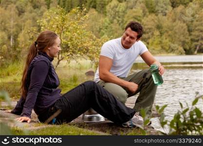 A couple cooking and making food outdoors on a camping trip