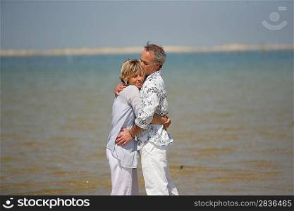 A couple embracing by the water