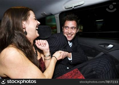 A couple having fun in the backseat of a taxi after a night out