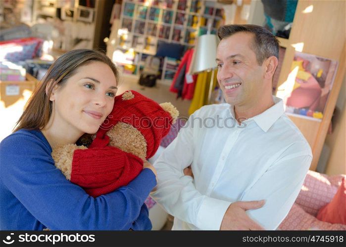a couple hugging a stuffed toy