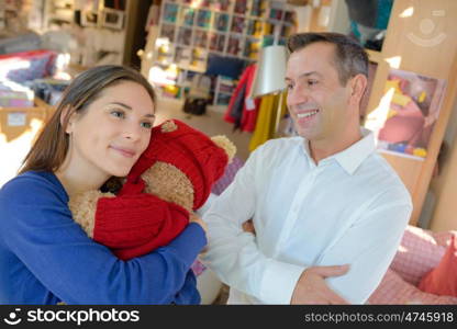 a couple hugging a stuffed toy