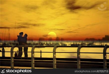 A couple in love on a pier at sunset, an image perfect valentine moment. Melbourne Australia.