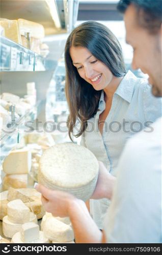 a couple is buying cheese