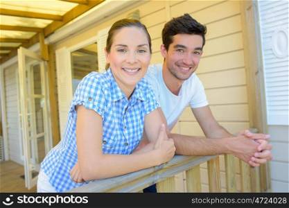 a couple is posing on the balcony